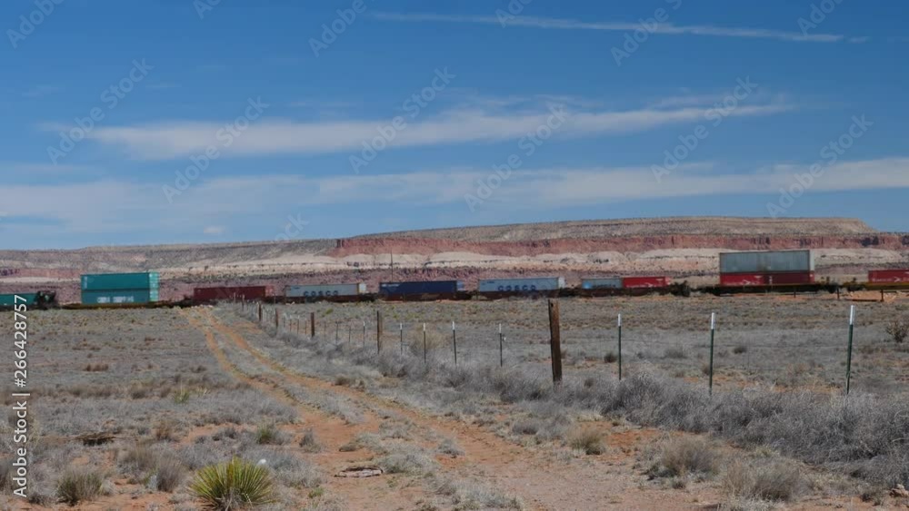 Red desert butte behind a moving cargo train Red desert butte behind a moving cargo train