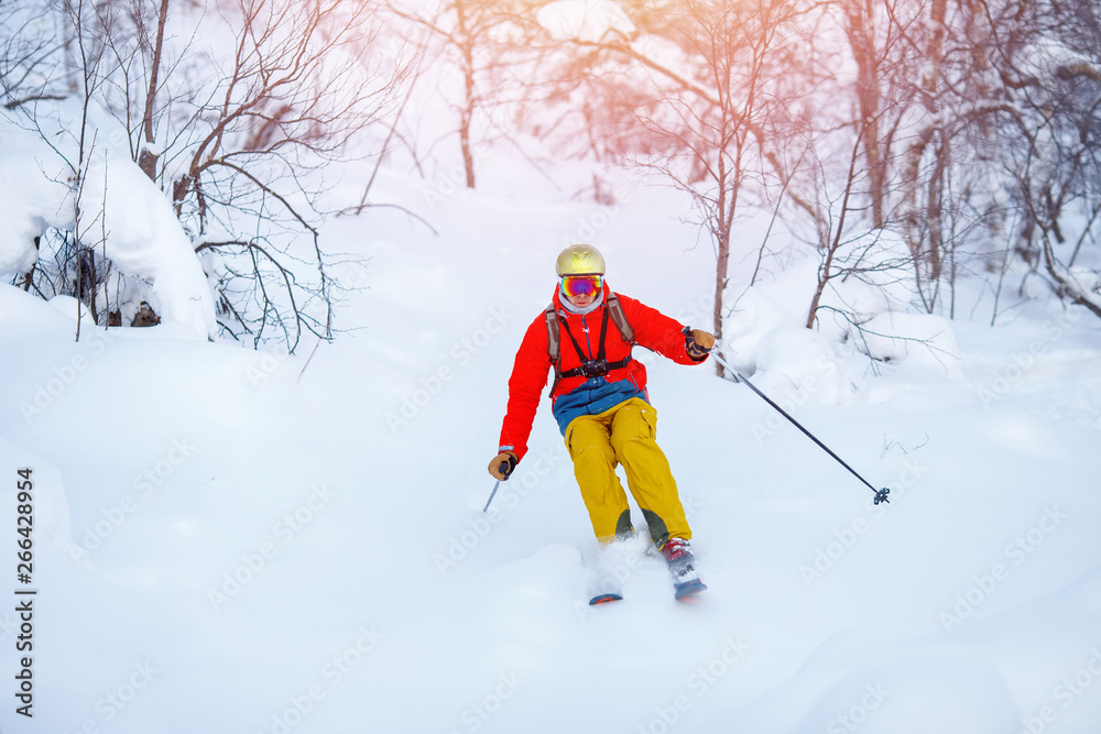 Young man skiing down mountain with ski poles Young man skiing down mountain with ski poles