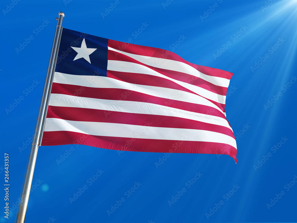 Liberia National Flag Waving on pole against deep blue sky background. High Definition