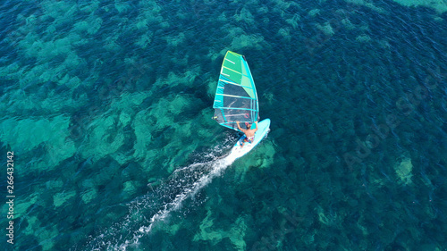 Aerial top view photo of fit man practising wind surfing in exotic open ocean bay with crystal clear emerald sea © aerial-drone