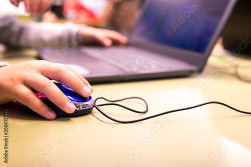 Valencia, Spain - April 13, 2019: Children using a laptop to play online.