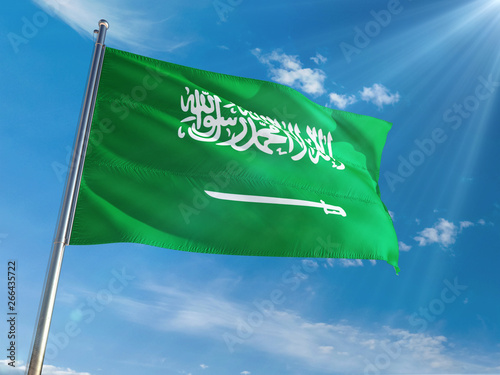 Saudi Arabia National Flag Waving on pole against sunny blue sky background. High Definition