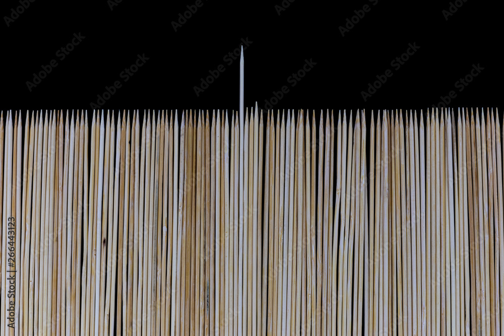 Wooden bamboo skewers set on a black backdrop for background purposes. Texture, natural Wooden bamboo skewers set on a black backdrop for background purposes. Texture, natural