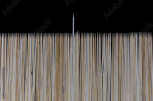 Wooden bamboo skewers set on a black backdrop for background purposes. Texture  natural