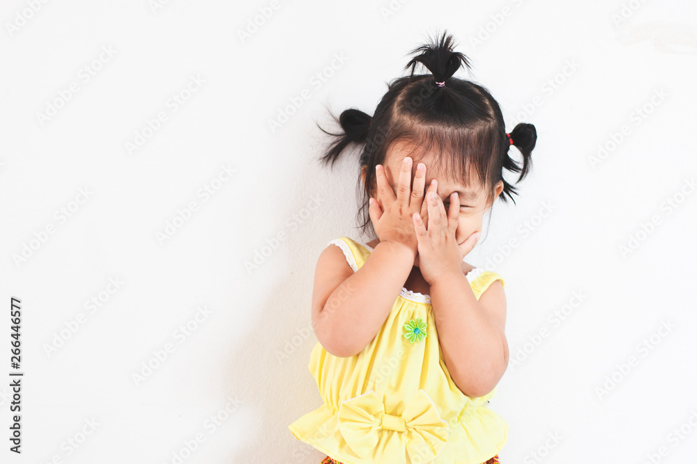 Cute asian baby girl closing her face and playing peekaboo or hide and seek with fun Cute asian baby girl closing her face and playing peekaboo or hide and seek with fun