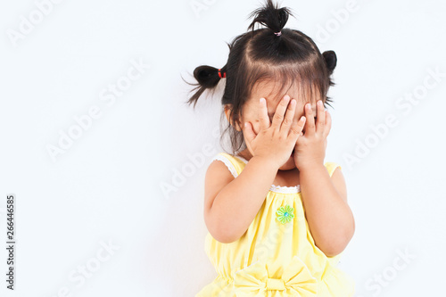 Foto Cute asian baby girl closing her face and playing peekaboo or hide and seek with