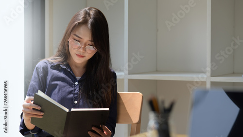 Portrait of Asian woman reading a book in library