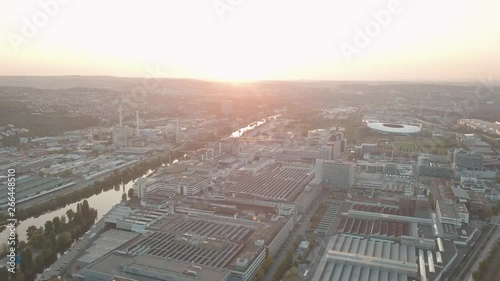 Aerial drone shot of beautiful Stuttgart, Germany while sunset with the Mercedes Benz Arena, the famous Volksfest Wasen and a lot of industry in the foreground and Stuttgart Downtown in the background photo