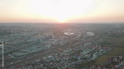 Aerial drone shot of beautiful Stuttgart, Germany while sunset with the Mercedes Benz Arena, the famous Volksfest Wasen and a lot of industry in the foreground and Stuttgart Downtown in the background photo