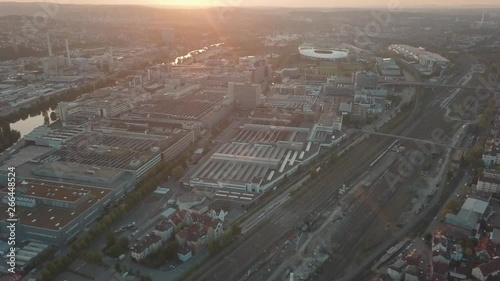 Aerial drone shot of beautiful Stuttgart, Germany while sunset with the Mercedes Benz Arena, the famous Volksfest Wasen and a lot of industry in the foreground and Stuttgart Downtown in the background photo