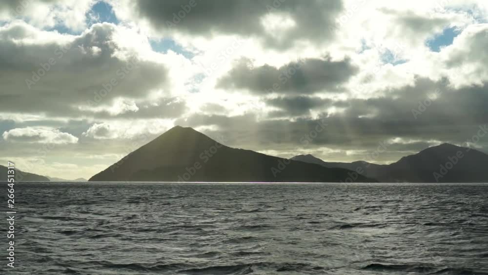 Morning view of sun, sky, clouds, hills and ocean from boat in Marlborough Sounds, New Zealand Morning view of sun, sky, clouds, hills and ocean from boat in Marlborough Sounds, New Zealand