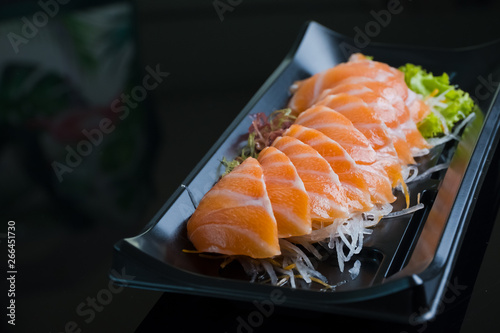 Łososiowy Sashimi na Czarnym Ceramicznym talerzu, czarny tło.