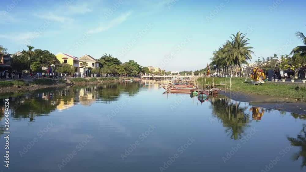 wonderful upper view calm river with mooring fishing boats and crowded embankments with green palms reflecting in water wonderful upper view calm river with mooring fishing boats and crowded embankments with green palms reflecting in water