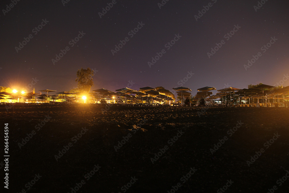 CHAMYUVA, TURKEY - 14 MAY 2014: Night skyline of Turkey and the starry sky, the empty beach, Camyuva, on the shore of the black sea, availability of places for sunbathing and thatc