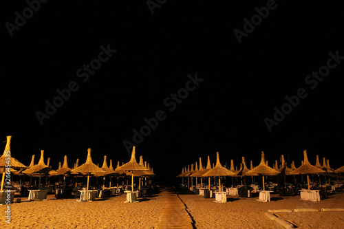 CHAMYUVA, TURKEY - 14 MAY 2014: Night beach in Turkey city Chamyuva, large umbrellas like mushrooms with a thatched roof, all places to relax are free photo