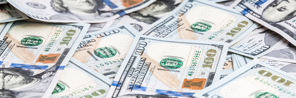 Background from dollars. Notes of one hundred American dollars are scattered across the background. Background from dollars. Notes of one hundred American dollars are scattered across the background.