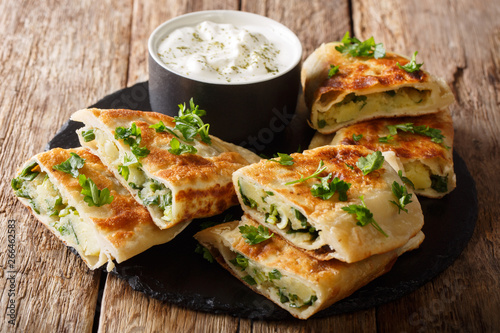 Rustic style afghan fried flatbread bolani stuffed with potatoes, green onions and cilantro close-up. horizontal