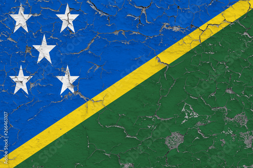 Flag of Solomon Islands painted on cracked dirty wall. National pattern on vintage style surface.