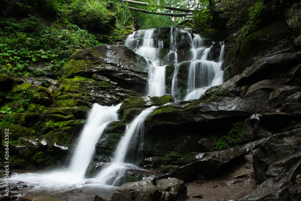 Large cascading waterfall in a mountain forest. Large cascading waterfall in a mountain forest.