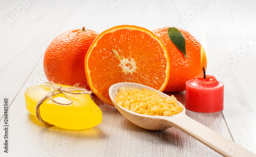 Cut orange with two whole oranges, soap, wooden spoon with sea salt and burning candle