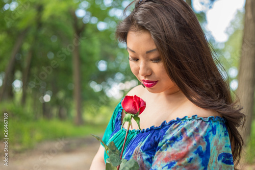 Young asian woman holding rose 