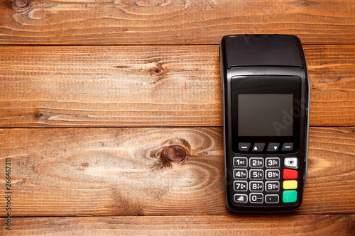 Payment terminal, compact POS terminal on wooden background top view copy space