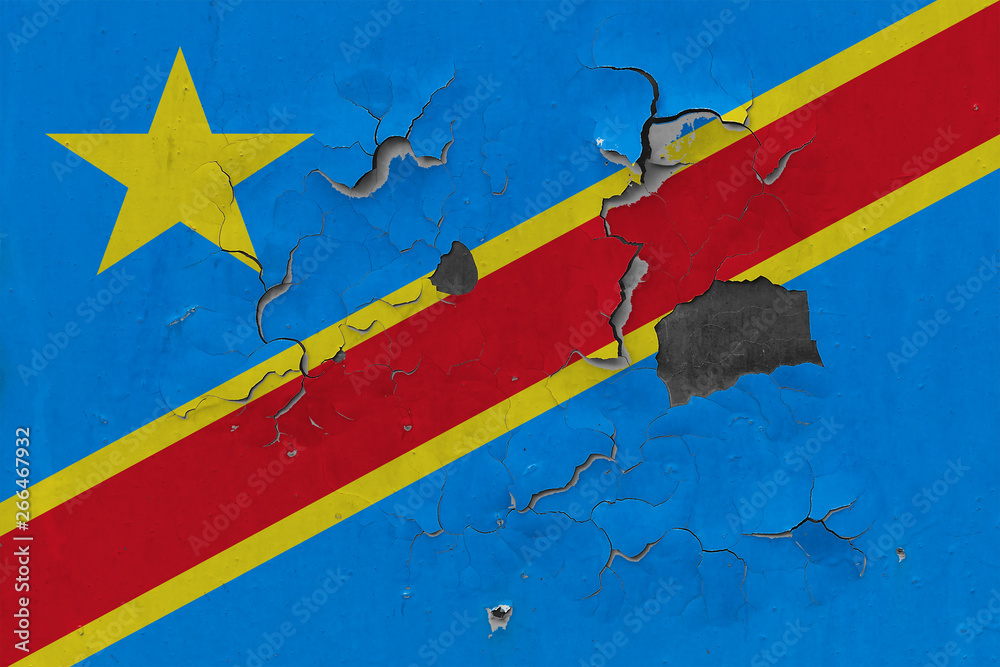 Close up grungy, damaged and weathered Congo flag on wall peeling off paint to see inside surface.