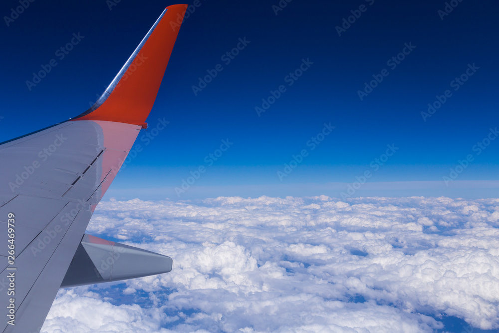 Aerial view of cloud blue sky and plane wing view through the airplane window. Copy space Aerial view of cloud blue sky and plane wing view through the airplane window. Copy space