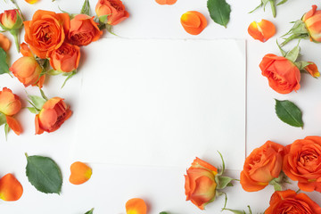 Framework from orange roses on white background. Flat lay. Top view