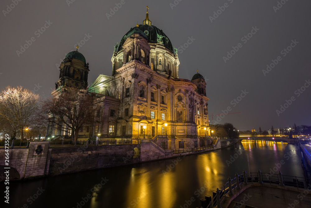 Beautiful view of illuminated Berliner Dom (Berlin Cathedral) by the Spree River in Berlin, Germany, at dusk.