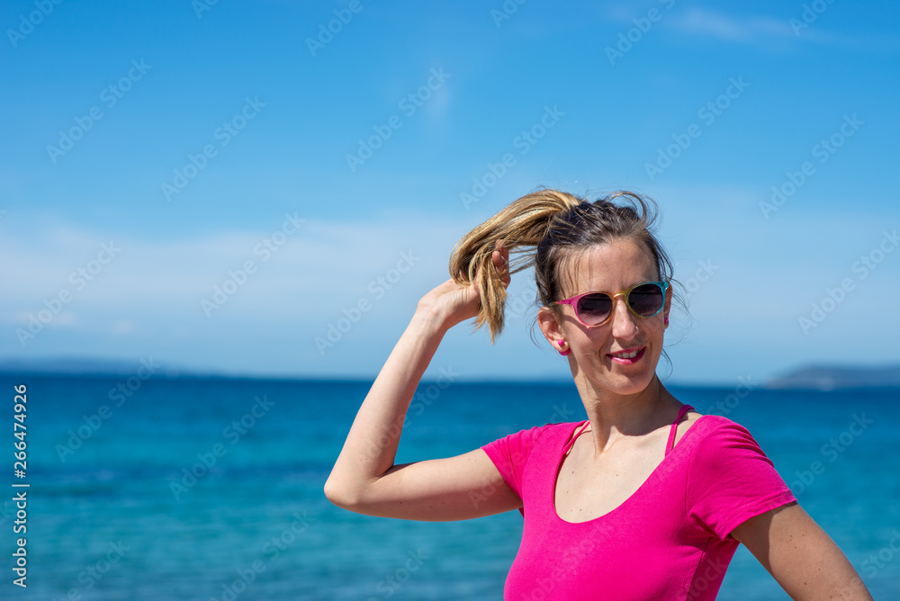 Young woman in pink shirt enjoying holidays at the seaside Young woman in pink shirt enjoying holidays at the seaside