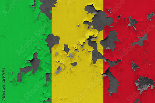 Close up grungy, damaged and weathered Mali flag on wall peeling off paint to see inside surface.