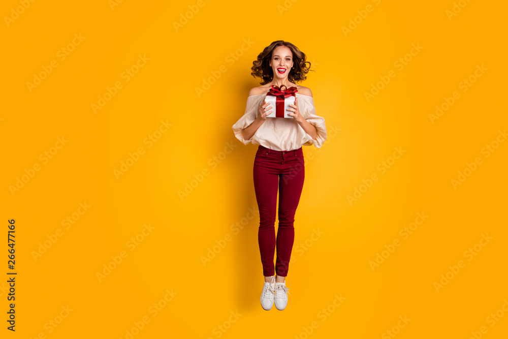 Full length body size view portrait of nice attractive lovely pretty glad cheerful cheery wavy-haired lady holding in hands festive box isolated over bright vivid shine yellow background Full length body size view portrait of nice attractive lovely pretty glad cheerful cheery wavy-haired lady holding in hands festive box isolated over bright vivid shine yellow background