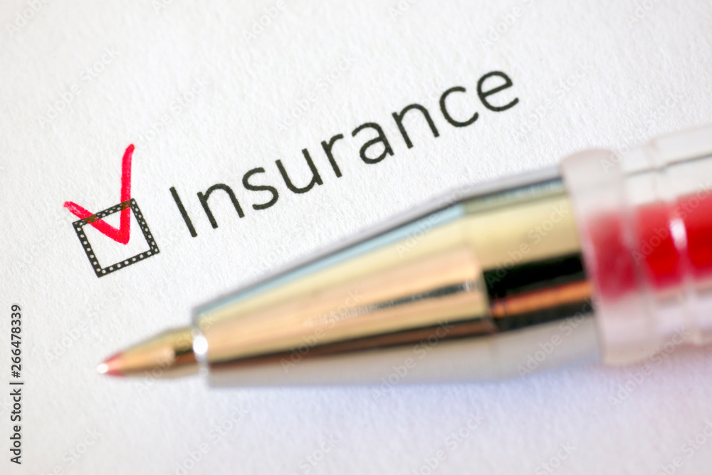 Questionnaire – red pen and the inscription INSURANCE with check mark on the white paper Questionnaire – red pen and the inscription INSURANCE with check mark on the white paper