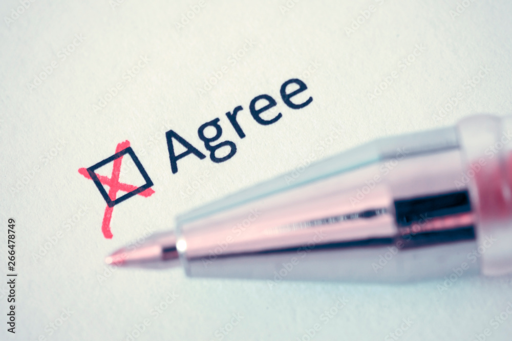 Questionnaire. Red pen and the inscription AGREE with cross on the white paper Questionnaire. Red pen and the inscription AGREE with cross on the white paper