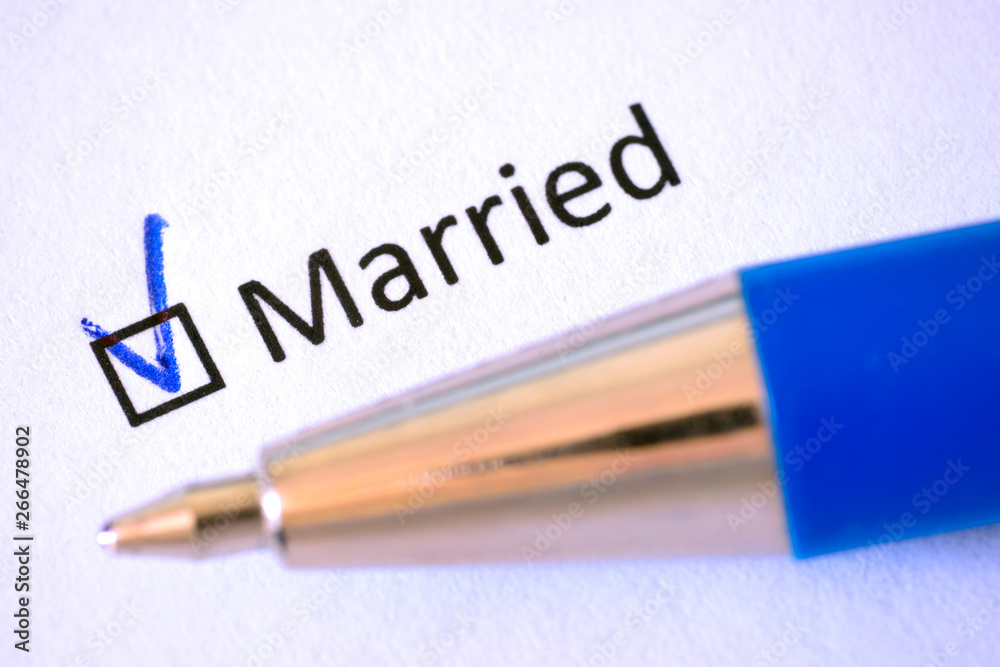 Questionnaire. Blue pen and the inscription MARRIED with check mark on the white paper