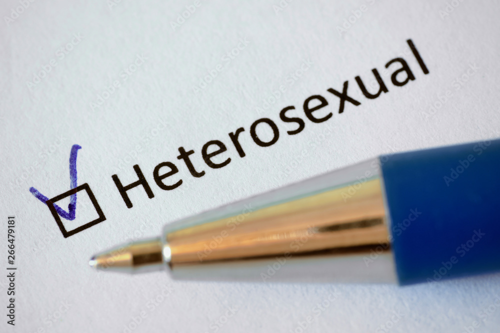 Questionnaire –  blue pen and the inscription HETEROSEXUAL with check mark on the white paper