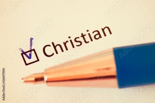 Questionnaire –  blue pen and the inscription CHRISTIAN with check mark on the white paper © watman