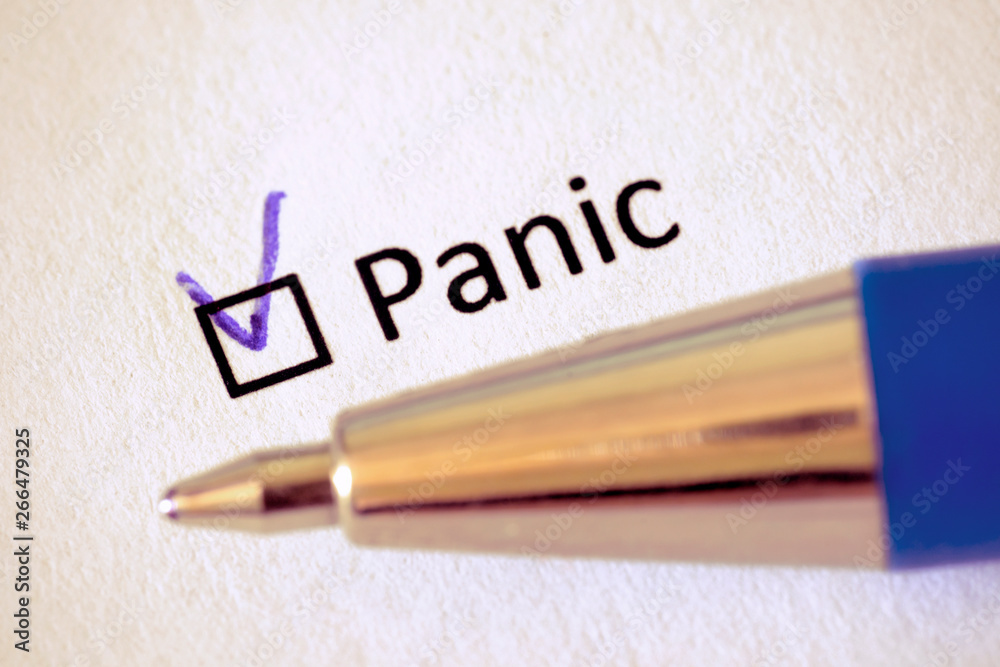 Questionnaire. Blue pen and the inscription PANIC with check mark on the white paper Questionnaire. Blue pen and the inscription PANIC with check mark on the white paper