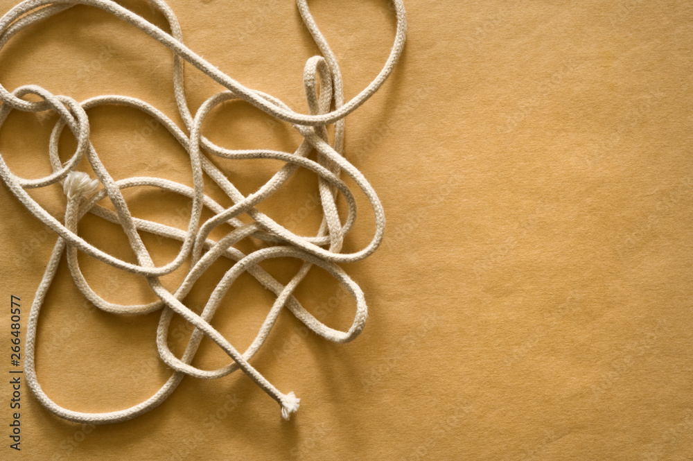 Tangled string on brown paper background. Tangled string on brown paper background.