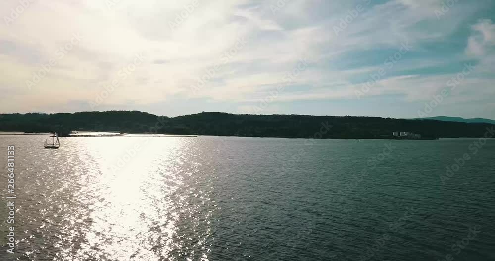 This is a miraculous aerial drone shot of a sailboat on the Hudson River sailing up river. This is a miraculous aerial drone shot of a sailboat on the Hudson River sailing up river.