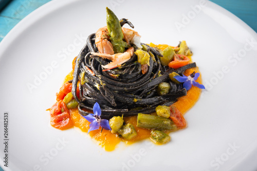 Fototapeta Naklejka Na Ścianę i Meble -  Tagliolini al nero di seppia con aragostelle e asparagi su crema di zucca