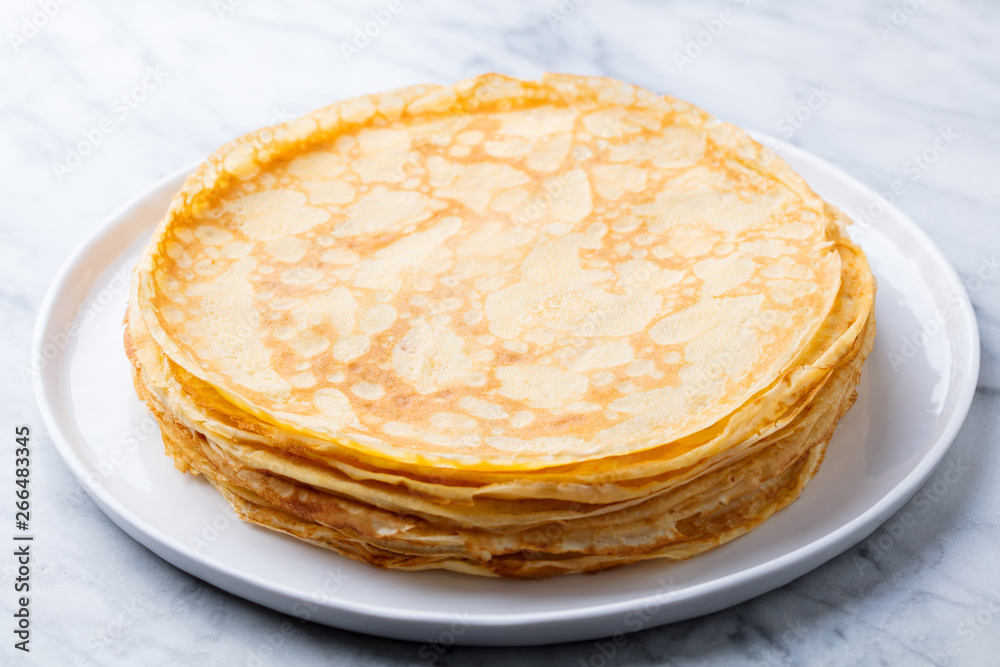 Crepes, thin pancakes with honey on a white plate. Marble background. Close up. Crepes, thin pancakes with honey on a white plate. Marble background. Close up.