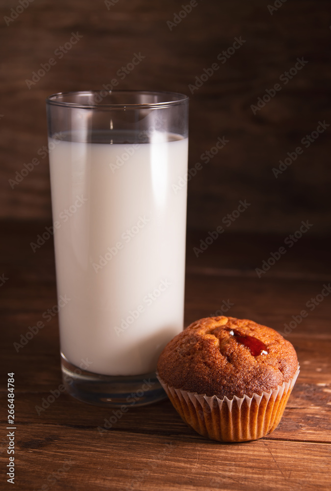 Fresh juicy muffins and a glass of milk on rustic wooden background Fresh juicy muffins and a glass of milk on rustic wooden background