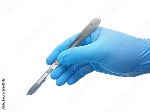 Fotografie, Obraz Hand of surgeon in blue medical glove holding a scalpel with blade isolated on w