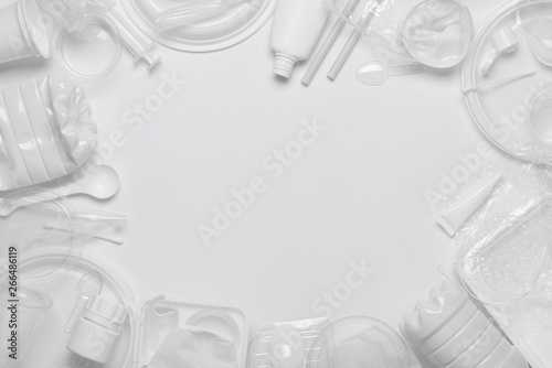 Plastic waste. Single-use plastic objects, ecological pollution. Frame poster background of white packaging plastic products. Top view flat lay.