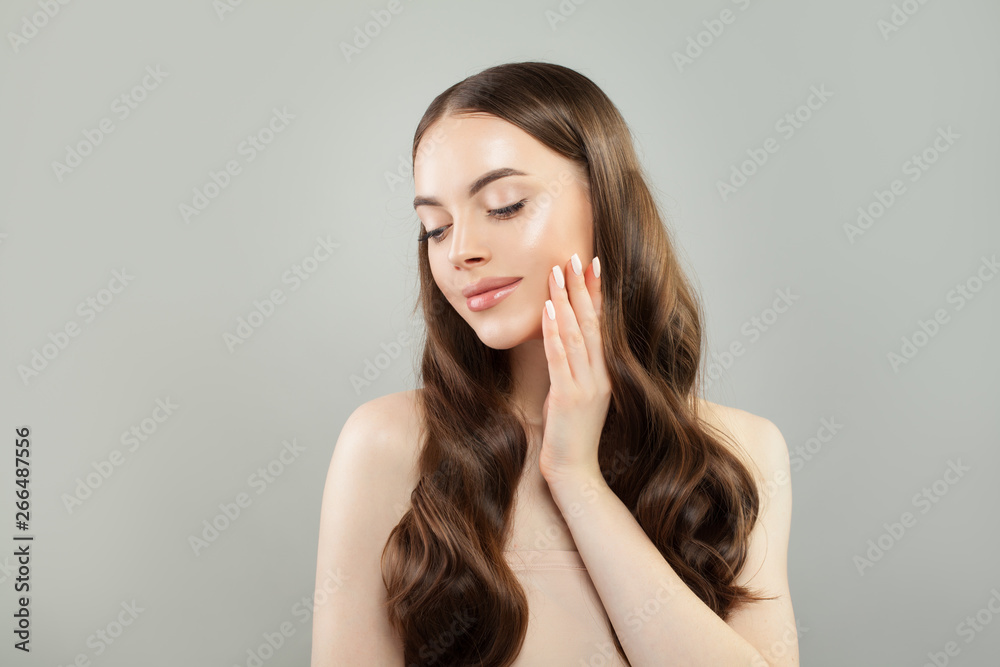 Beautiful female model with clear skin and brown curly hair. Skincare and haircare concept Beautiful female model with clear skin and brown curly hair. Skincare and haircare concept