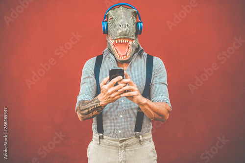 Tattooed man with t-rex mas...