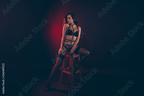Full length body size portrait of nice attractive sportive fit thin perfect wavy-haired lady wearing swordbelt sitting on bar stool enjoying lifestyle isolated over red light black background