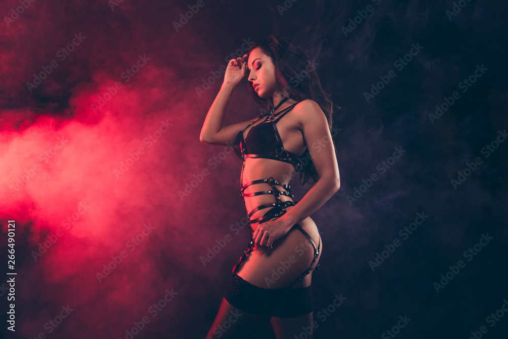 Fototapeta premium Profile side view portrait of nice lovely stunning charming dreamy attractive sportive shape wavy-haired lady wearing swordbelt posing teasing isolated on black red light background